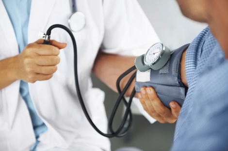 doctor taking patient's blood pressure
